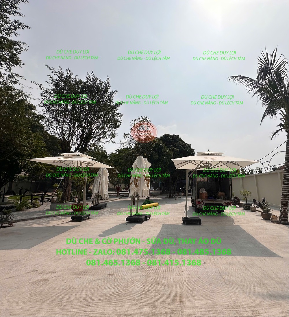 Dù lệch tâm màu sáng đặt tại khoảng sân rộng, với đế nằm ngoài khu bàn ghế.