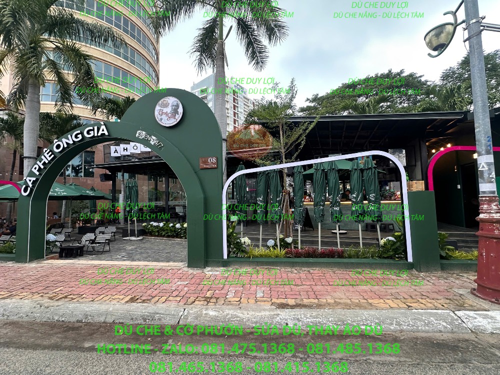 Không gian cafe có cây xanh, khu vui chơi và dù màu xanh phía bên trong.