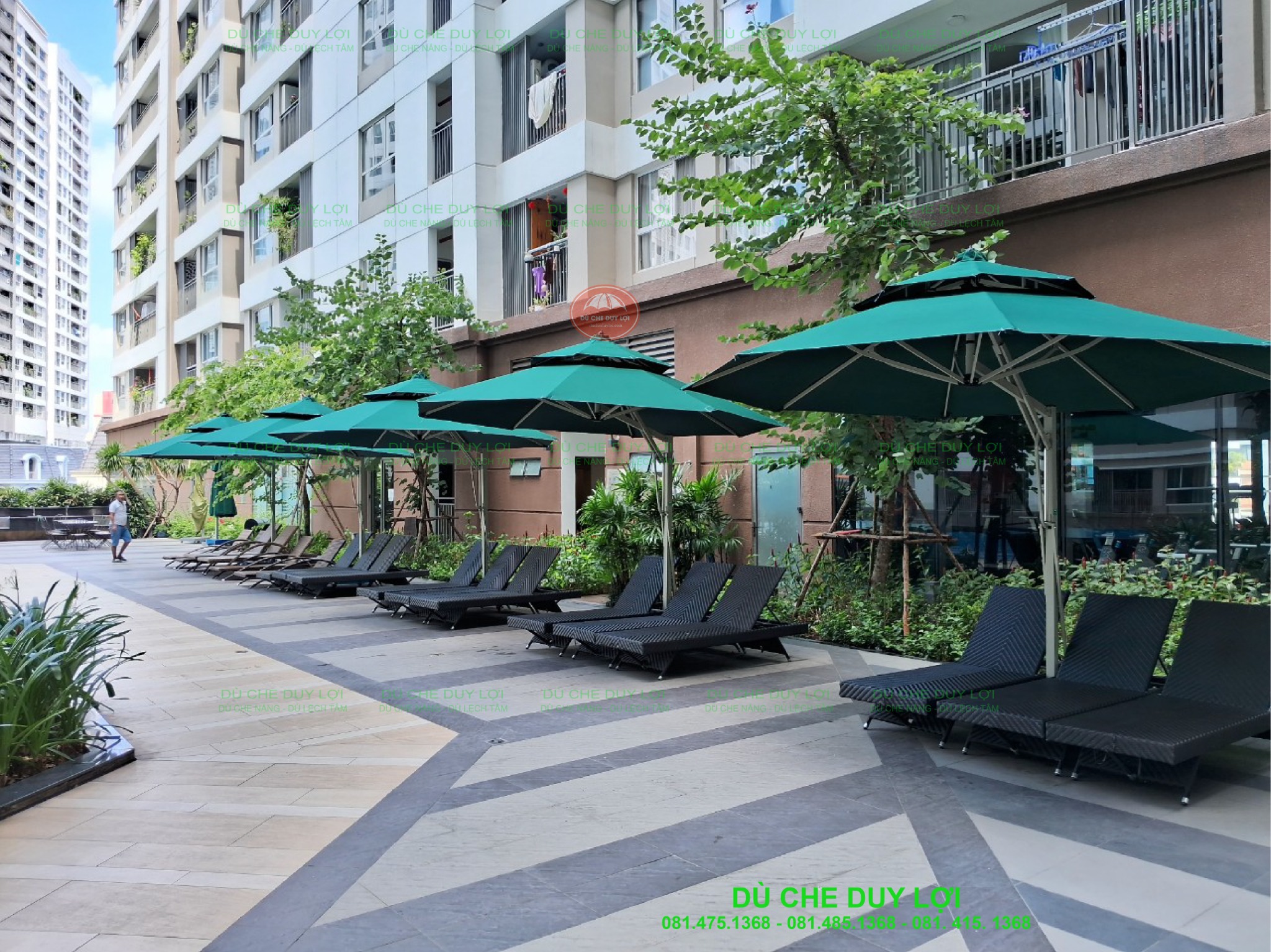D&atilde;y d&ugrave; lệch t&acirc;m tr&ograve;n m&agrave;u xanh che ghế nghỉ b&ecirc;n lối đi cạnh hồ bơi.
