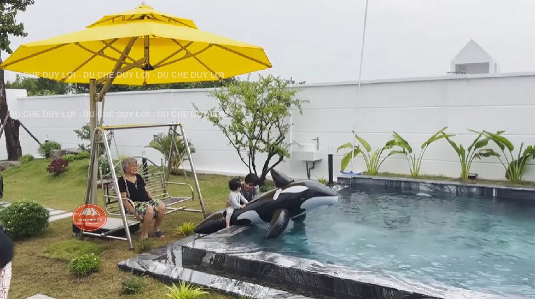 D&ugrave; lệch t&acirc;m tr&ograve;n m&agrave;u v&agrave;ng che khu ghế ngồi b&ecirc;n hồ bơi nhỏ v&agrave; s&acirc;n cỏ.