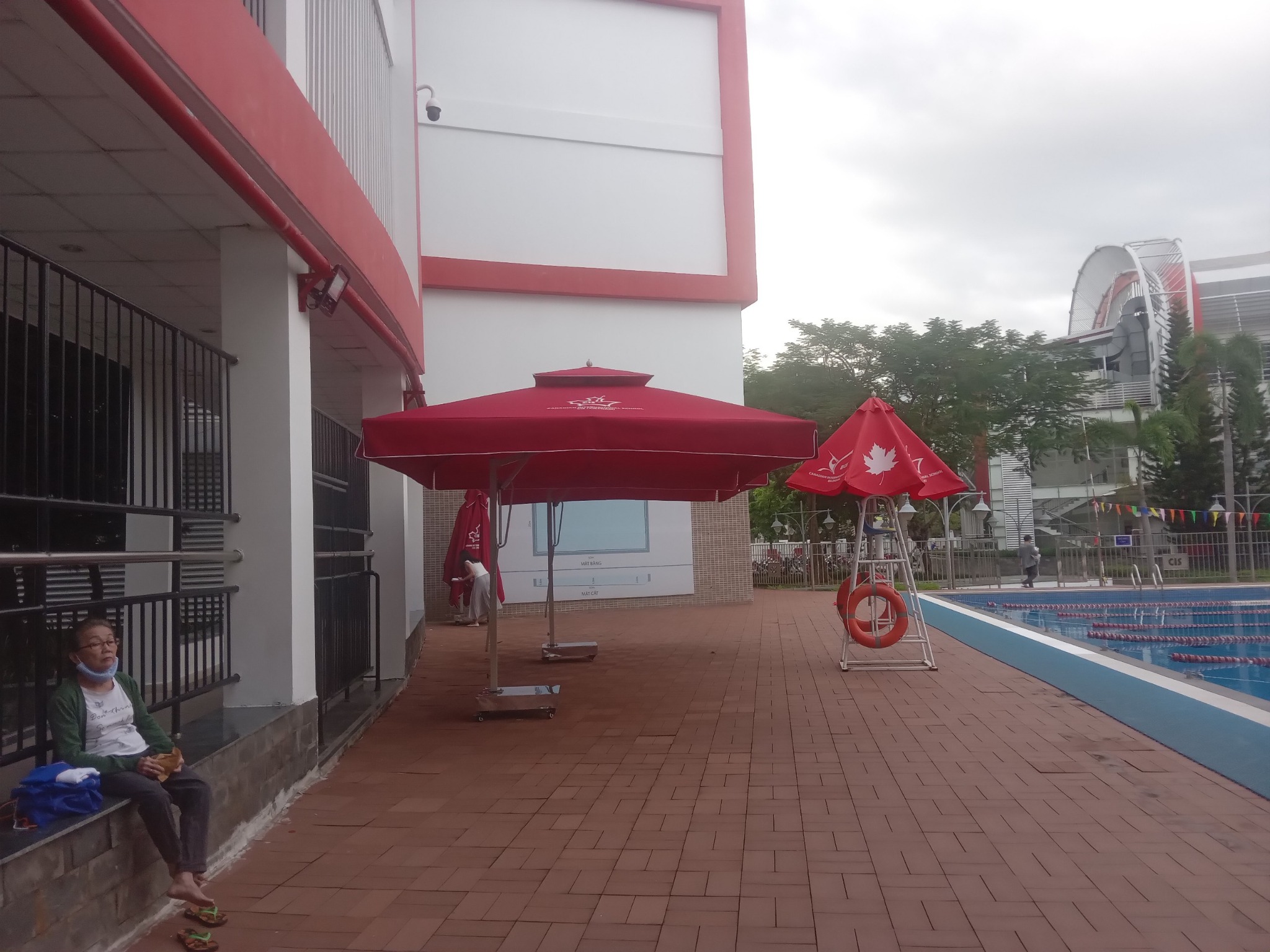D&ugrave; lệch t&acirc;m vu&ocirc;ng m&agrave;u đỏ đặt tr&ecirc;n lối đi l&aacute;t gạch b&ecirc;n c&ocirc;ng tr&igrave;nh v&agrave; hồ bơi.