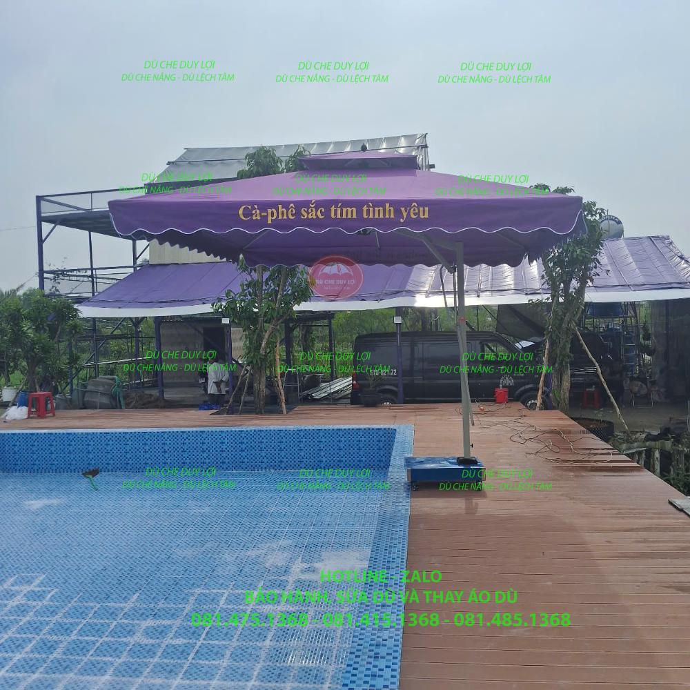 D&ugrave; lệch t&acirc;m vu&ocirc;ng m&agrave;u t&iacute;m in nội dung tr&ecirc;n diềm &aacute;o, đặt cạnh hồ bơi.
