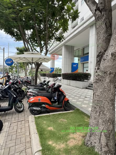 D&ugrave; che nắng m&agrave;u trắng kem tại khu vực để xe trước điểm giao dịch VIB.
