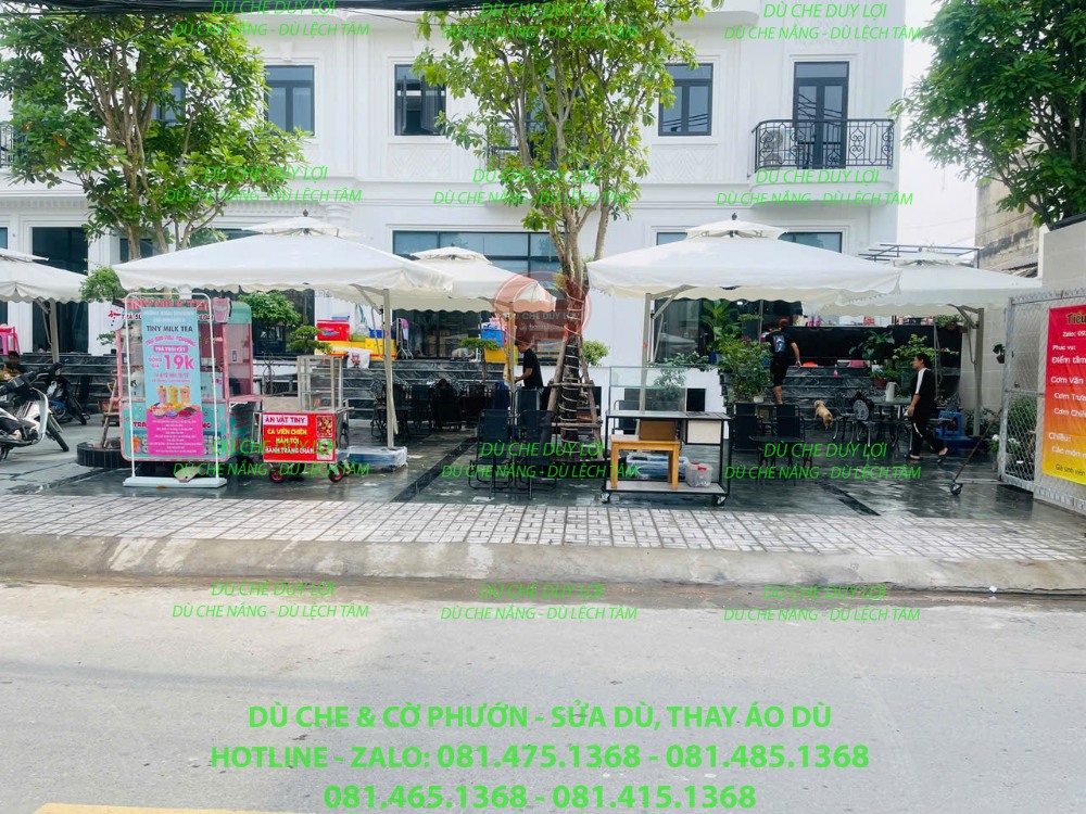 D&atilde;y d&ugrave; m&agrave;u s&aacute;ng che khu b&agrave;n ghế tại mặt tiền qu&aacute;n cafe.
